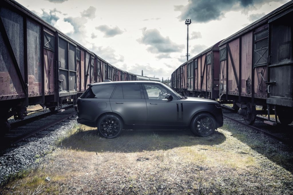 Fotoshooting eines Range Rovers mit der Car Wrapping Folie Matt Diamond Black vor alten Eisenbahnwagongs.